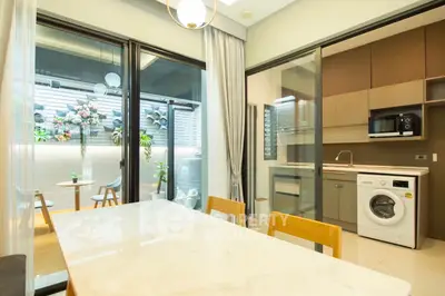 Modern kitchen with washing machine and open layout, featuring a bright dining area and outdoor view.