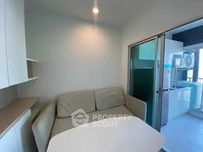 Modern compact living space with cozy sofa and sleek kitchen area, perfect for urban living.