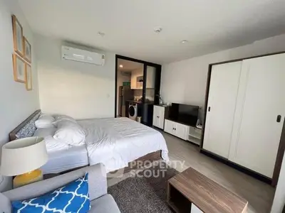 Modern studio apartment with cozy bedroom and compact kitchen area.