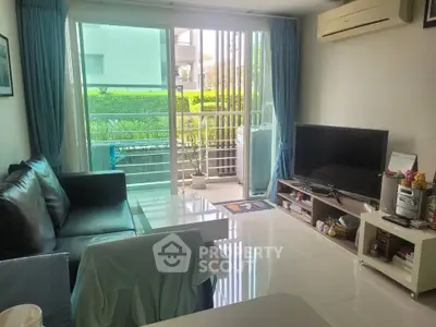 Cozy living room with modern furniture and balcony view in a bright apartment.