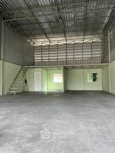Spacious industrial-style warehouse with high ceilings and mezzanine level.