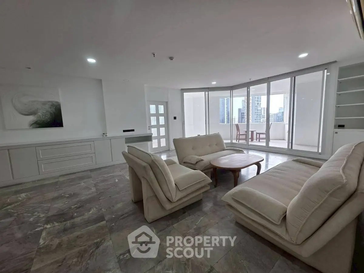 Spacious modern living room with elegant furniture and city view balcony.