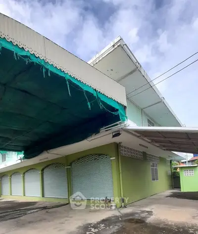 Spacious green building with covered parking and modern design