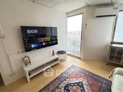 Modern living room with wall-mounted TV and balcony access in urban apartment