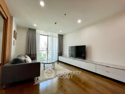 Spacious modern living room with large TV and city view, perfect for relaxation and entertainment.