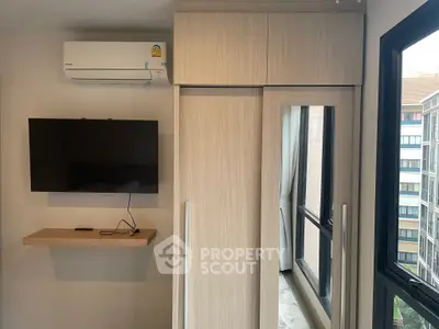 Modern bedroom with wall-mounted TV and large window view