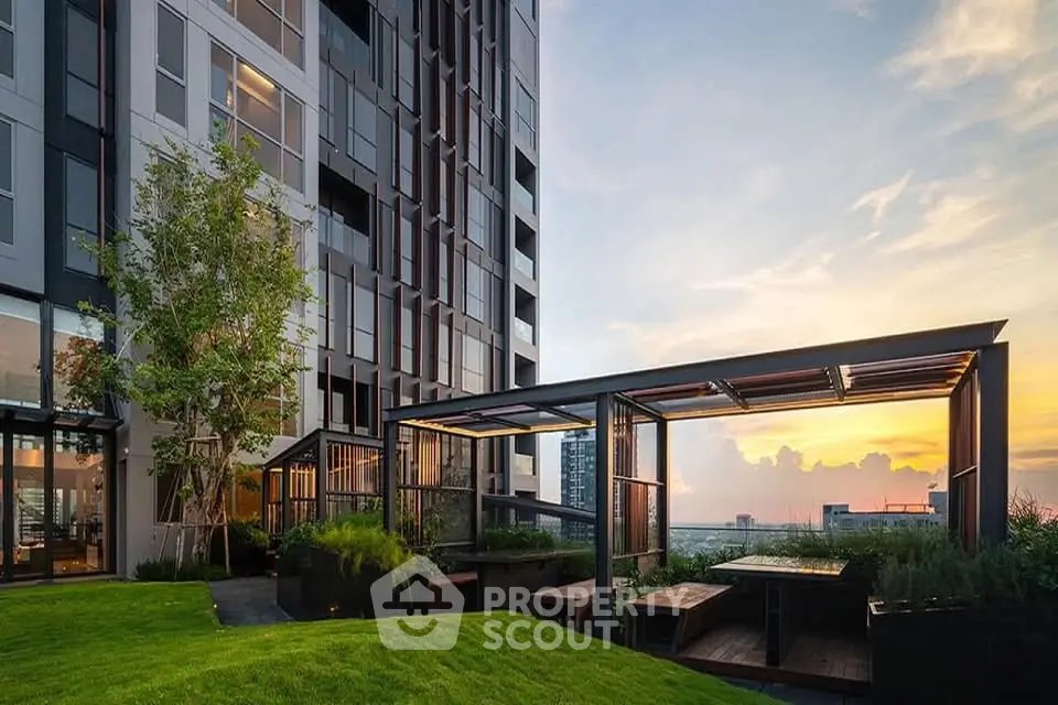 Modern building exterior with lush garden and sunset view