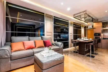 Luxurious modern living room with open kitchen, stylish decor, and cozy seating area.