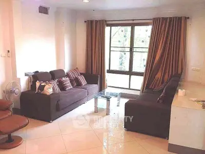 Spacious living room with modern furniture and large window view.