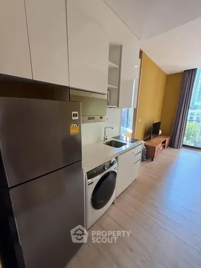 Modern kitchen with sleek appliances and open layout in a stylish apartment.