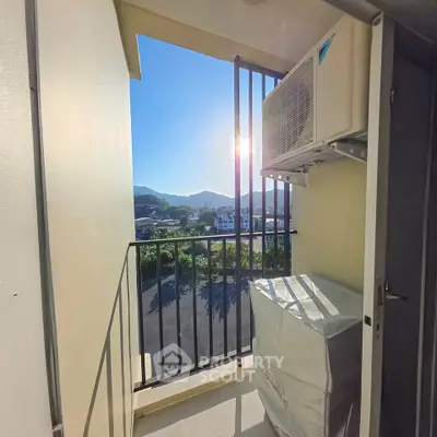 Charming balcony with scenic mountain view and air conditioning unit, perfect for relaxation.