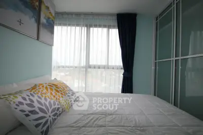 Cozy bedroom with large window and modern decor in a stylish apartment.