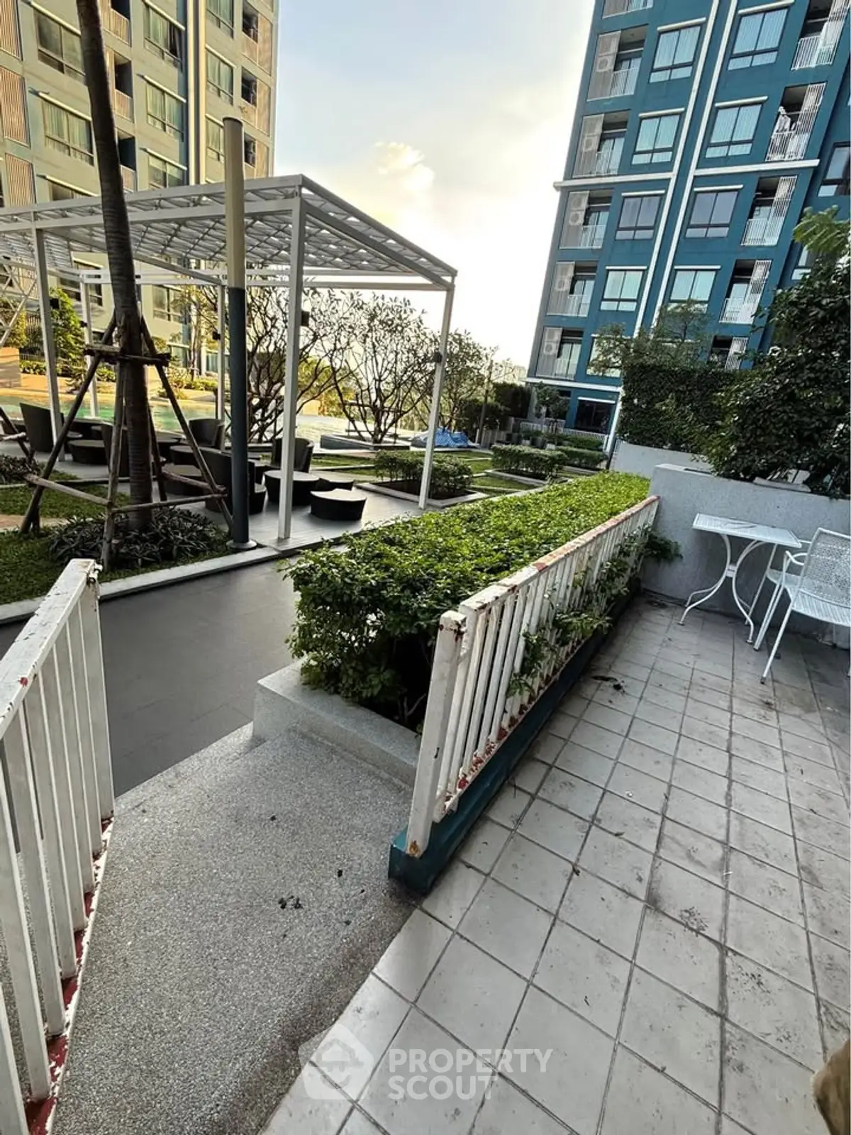 Modern apartment complex with lush garden and outdoor seating area