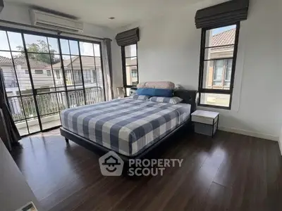 Spacious bedroom with large windows and modern decor in a stylish home.