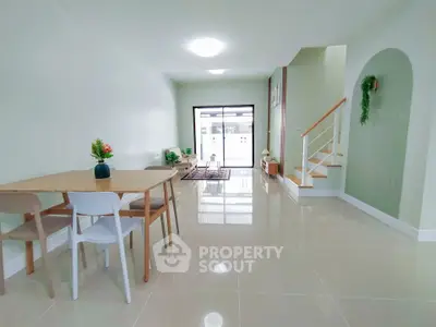 Spacious modern living room with sleek tile flooring and elegant staircase