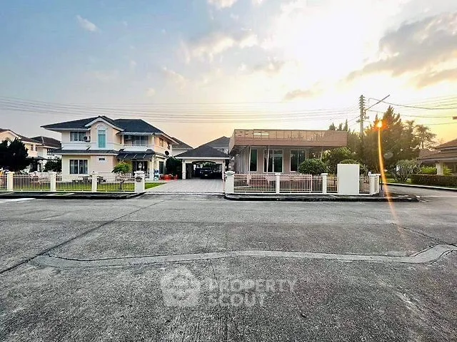 Charming suburban homes with spacious driveways and lush gardens at sunset.