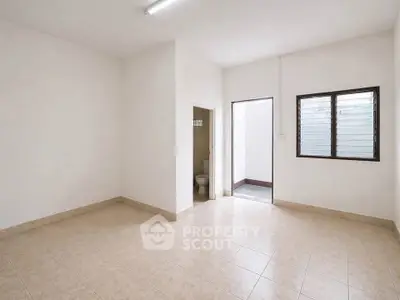 Spacious unfurnished room with tiled floor and natural light, ideal for customization.