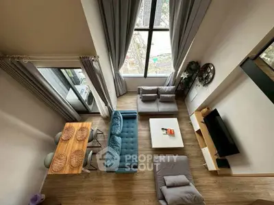 Stunning high-ceiling living room with modern decor and city view