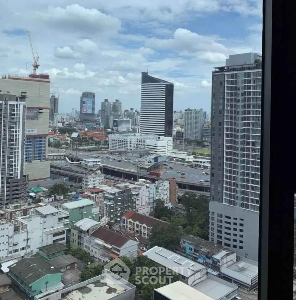 Stunning cityscape view from high-rise apartment window showcasing urban skyline and modern architecture.