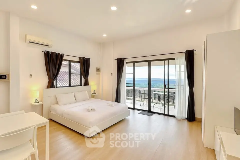 Spacious bedroom with balcony offering stunning views and modern decor