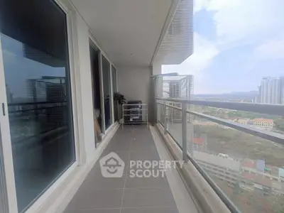 Spacious balcony with stunning city view in modern high-rise apartment.