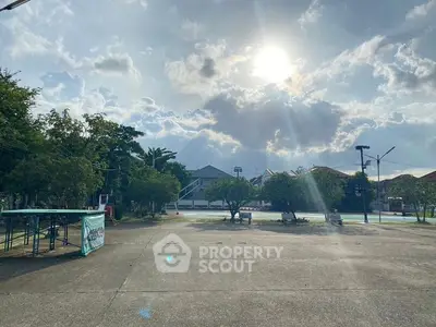 Spacious outdoor area with clear sky and trees, ideal for recreational activities.