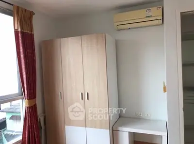 Cozy bedroom with wardrobe and air conditioning unit, perfect for comfortable living.