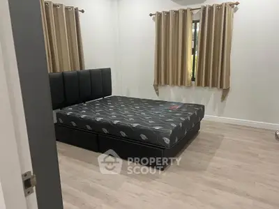 Spacious bedroom with modern bed and elegant curtains, perfect for comfort and relaxation.