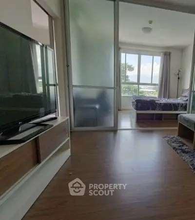 Modern apartment with spacious bedroom and living area, featuring large windows and sleek flooring.