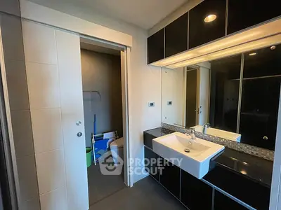 Modern bathroom with sleek black cabinetry and large mirror