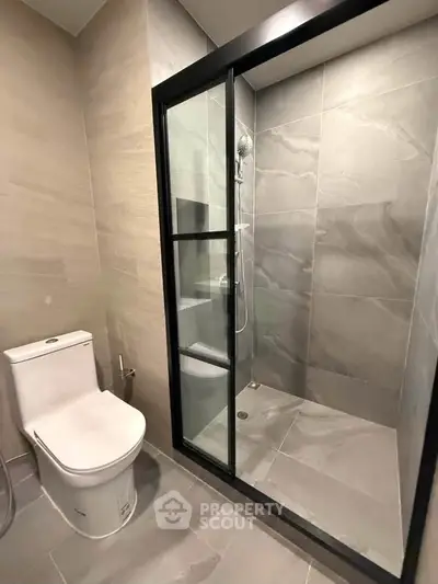 Modern bathroom with sleek shower enclosure and contemporary toilet design.