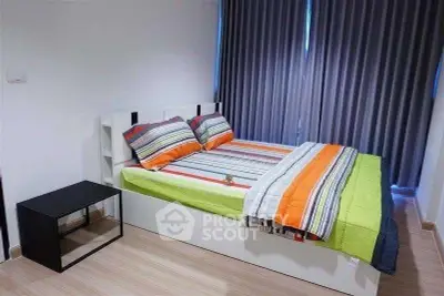 Modern bedroom with colorful bedding and sleek furniture in a stylish apartment.