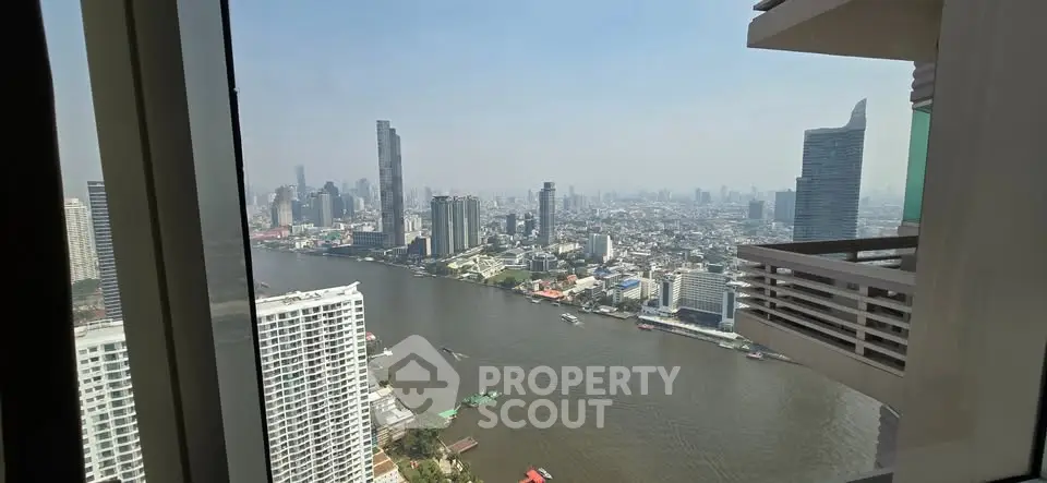 Stunning cityscape view from high-rise apartment overlooking river and skyline.