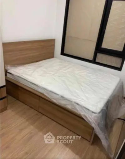 Cozy bedroom with wooden flooring and a comfortable bed, perfect for relaxation.