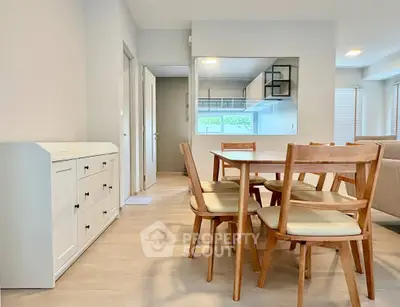 Modern dining area with wooden furniture and open kitchen layout in a bright apartment.