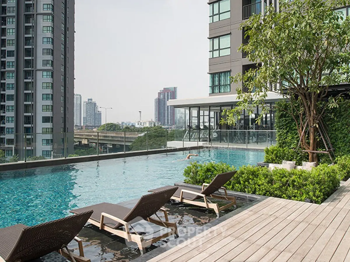Luxurious rooftop pool with city skyline view in modern high-rise building.