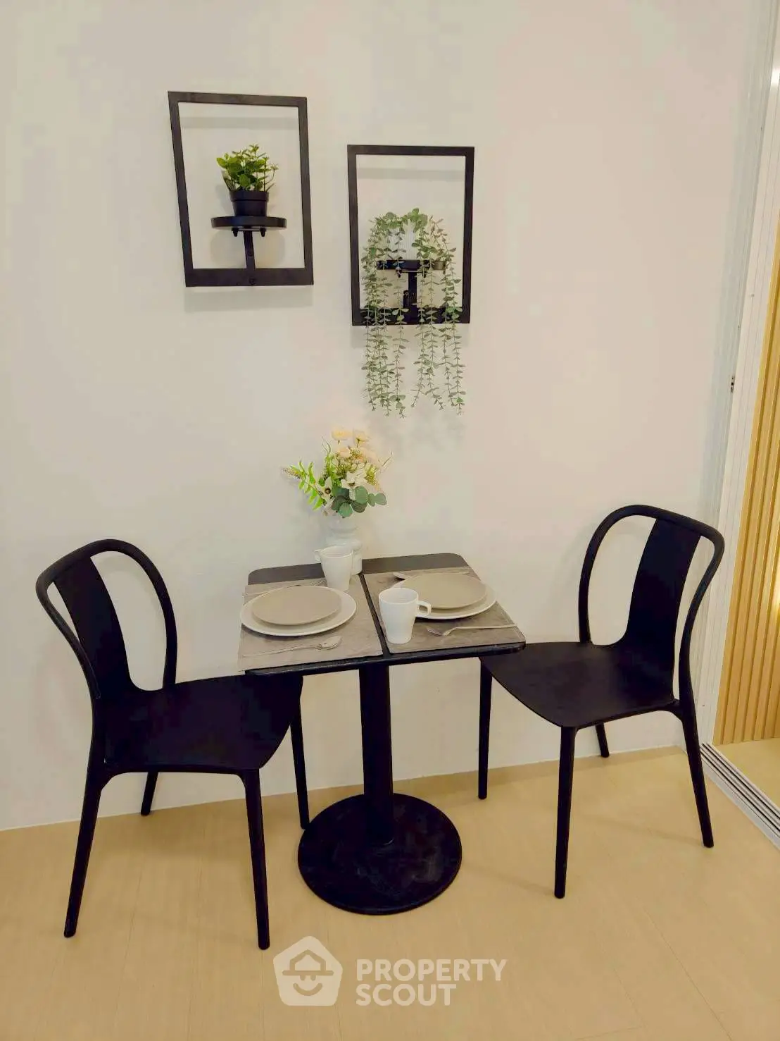 Charming dining nook with modern black chairs and decorative wall plants.