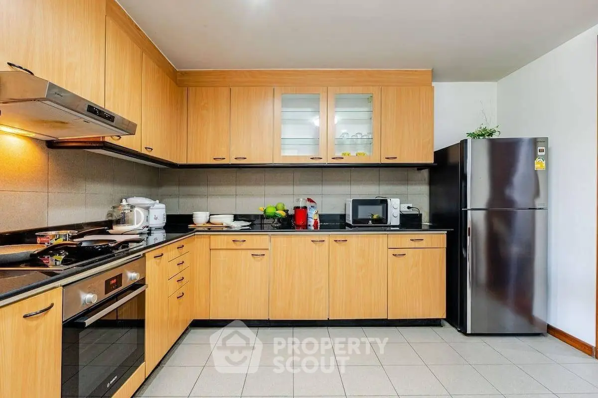 Spacious modern kitchen with wooden cabinets and stainless steel appliances