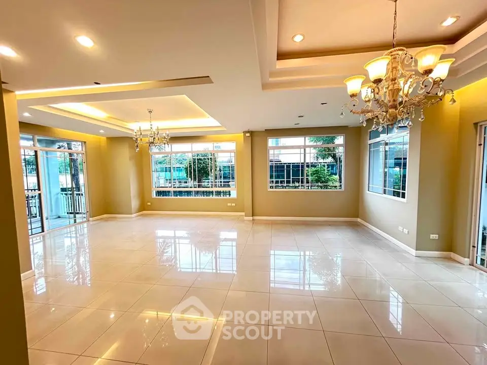 Spacious and elegant living room with chandeliers and large windows