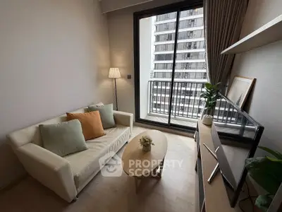 Modern living room with cozy sofa, stylish decor, and balcony view in urban apartment.