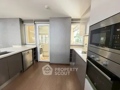 Modern kitchen with sleek appliances and wooden flooring