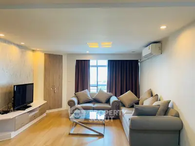Spacious living room with modern furniture and large window offering natural light.