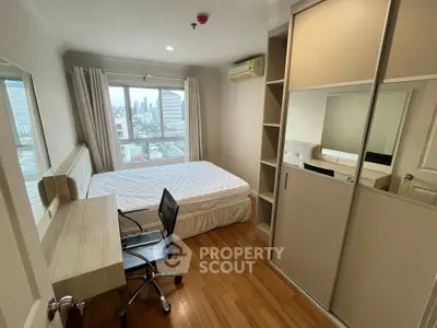 Modern bedroom with city view, featuring a comfortable bed, sleek desk, and ample storage space.