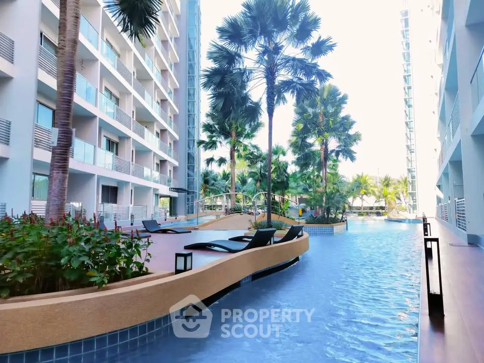 Luxurious apartment complex with stunning poolside view and lush palm trees.