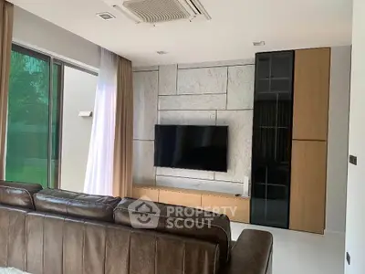 Modern living room with sleek TV setup and stylish furniture, perfect for relaxation and entertainment.