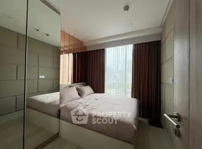 Modern bedroom with large window and mirrored closet in urban apartment