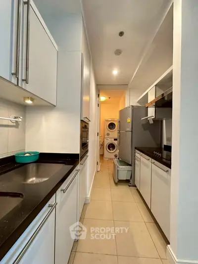 Modern kitchen with sleek appliances and laundry area in a compact layout