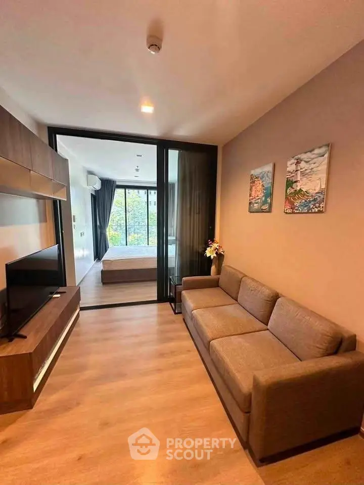 Modern living room with sleek design and cozy ambiance, featuring a comfortable sofa and large TV.