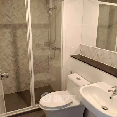 Modern bathroom with glass shower and sleek fixtures in contemporary apartment.