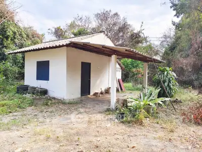 Charming rustic house with a covered porch surrounded by lush greenery, perfect for nature lovers seeking tranquility.